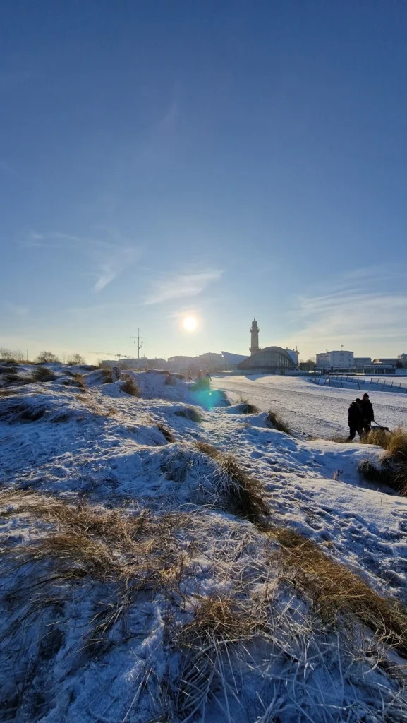Winterliche Szene an der Ostseeküste bei Warnemünde mit leichtem Schneebelag auf den Dünen.